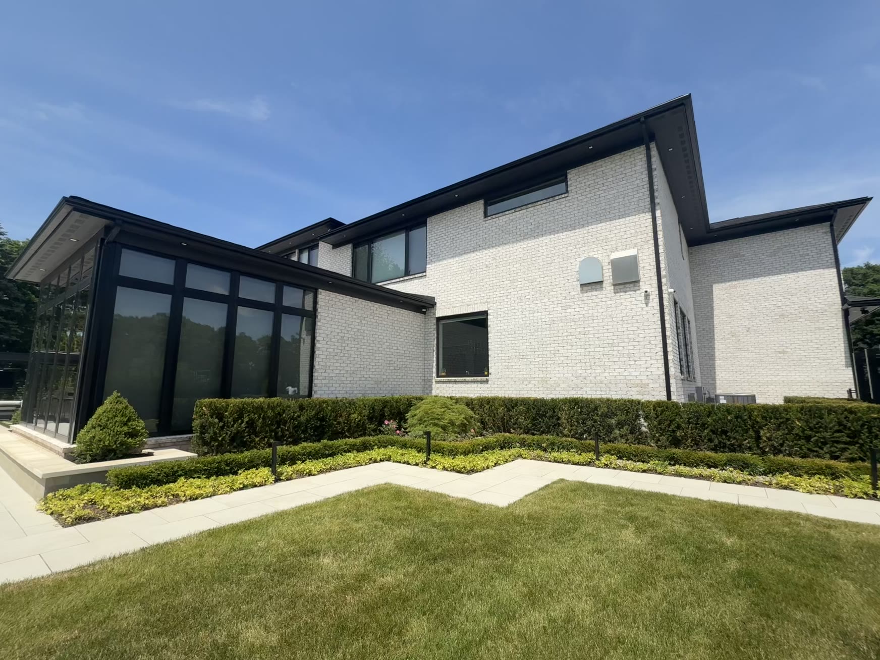 Modern white-brick two-story luxury home in Metro Detroit with crystal-clear windows cleaned by Apex Exteriors