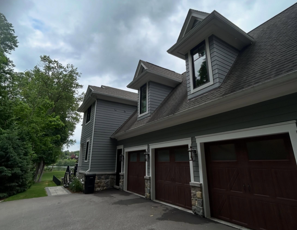 Side elevation of a Bloomfield Hills home showing dormer windows and lakeside garage after Apex Exteriors clean
